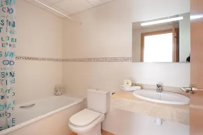 a bathroom with a toilet and a sink and a tub at Blaumar in Sitges