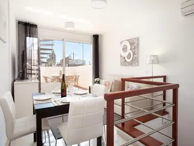 a dining room with a table and white chairs at Blaumar in Sitges