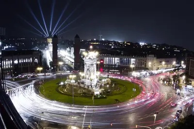 a city at night with a clock tower in the middle at Habitat Apartments Blanca in Barcelona