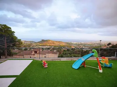 a playground with a slide on the grass at A+View Private Terrace Private Pool Family Fun in Badalona