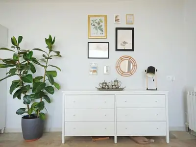 a white dresser in a white room with a plant at A+View Private Terrace Private Pool Family Fun in Badalona