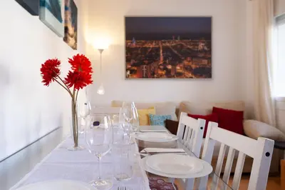 a dining room table with glasses and a vase with a red flower at Cute Apartment in Sants Station with HBO & Alexa & AC in Barcelona