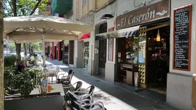 an outdoor cafe with tables and chairs and an umbrella at Cute Apartment in Sants Station with HBO & Alexa & AC in Barcelona