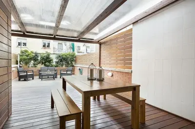a patio with a table and benches on a deck at Stay U-nique House Torre Damians in Barcelona