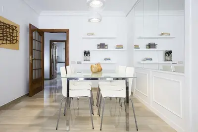 a white kitchen with a table and white chairs at Stay U-nique House Torre Damians in Barcelona