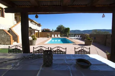 a table with a blue table cloth on a patio with a pool at Catalunya Casas Indoor and Outdoor Pools, Sauna, Gym, Games Area in Sant Pau dʼOrdal