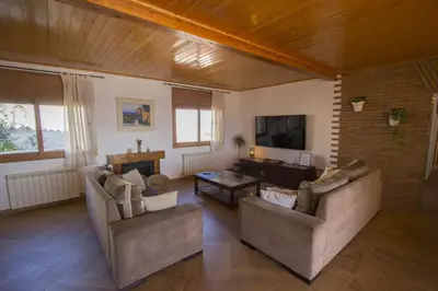a living room with two couches and a tv at Catalunya Casas Indoor and Outdoor Pools, Sauna, Gym, Games Area in Sant Pau dʼOrdal
