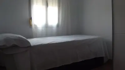 a white bedroom with a bed and a window at Apartamentos Atlas Terrassa I in Terrassa