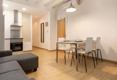 a living room with a table and chairs and a couch at Gothic - Ramblas Apartments in Barcelona