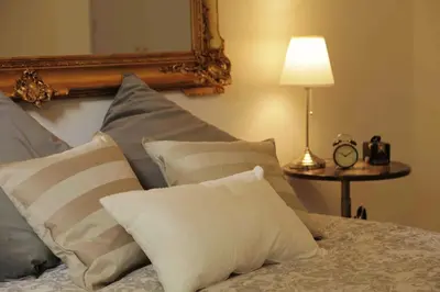 a bed with pillows and a mirror and a lamp at Rafael Music Palace apartment in Barcelona