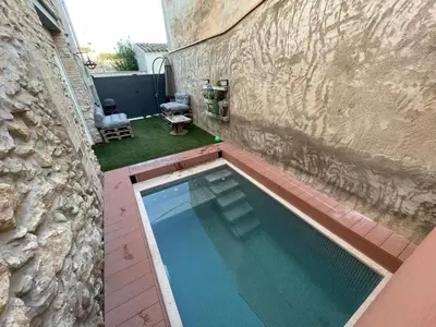 a swimming pool in the side of a building at Cal Tomaset in Les Cabanyes