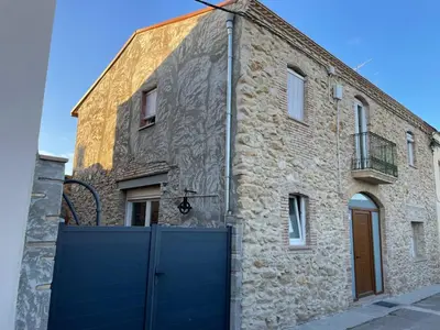 a building with a blue gate in front of it at Cal Tomaset in Les Cabanyes