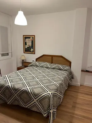 a bedroom with a bed with a comforter on it at Ancora Apartment in Vilanova i la Geltrú