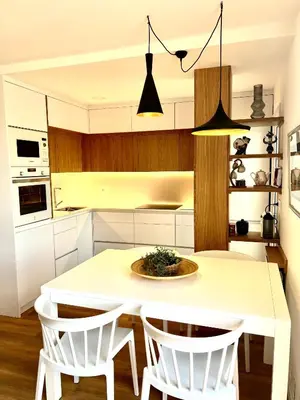 a kitchen with a white table and white chairs at Ancora Apartment in Vilanova i la Geltrú