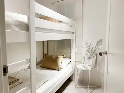 a white bunk bed in a white room with a pillow at White Apartment Barcelona in Barcelona