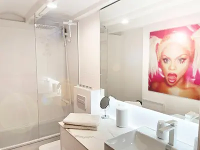 a bathroom with a painting of a woman on the wall at White Apartment Barcelona in Barcelona