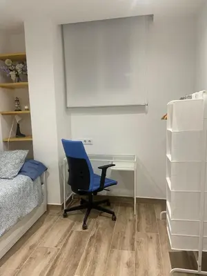 a bedroom with a blue chair and a desk at APARTAMENTO EN LA PLAYA in Pineda de Mar