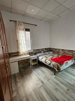 a bedroom with a bed and a desk and a window at Habitación doble con baño privado in Hospitalet de Llobregat