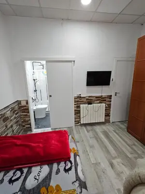 a living room with a red couch and a flat screen tv at Habitación doble con baño privado in Hospitalet de Llobregat