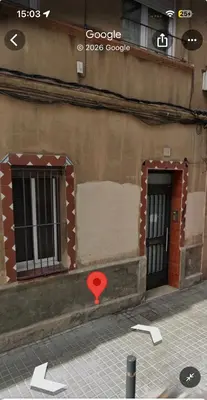 a building with two windows and a red door at Habitación doble con baño privado in Hospitalet de Llobregat