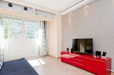 a living room with a flat screen tv on a red cabinet at Glorias:Sagrada Familia 15 minutos - Playa 20 minutos in Barcelona