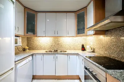 a kitchen with white cabinets and a sink at Comfy Downtown + Private terrace in Barcelona