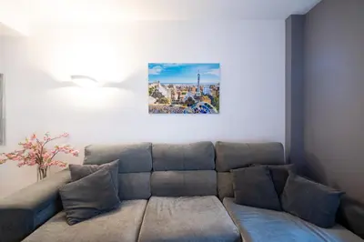 a couch in a living room with a painting on the wall at Comfy Downtown + Private terrace in Barcelona
