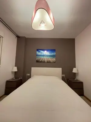 a bedroom with a white bed and two lamps at Comfy Downtown + Private terrace in Barcelona