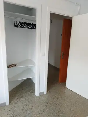 a room with a closet with white shelves and a door at Apartament IXA-2 in Manresa