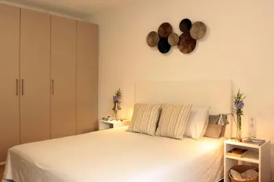 a bedroom with a white bed and a clock on the wall at Comfortable apartment. Very central and quiet. in Barcelona