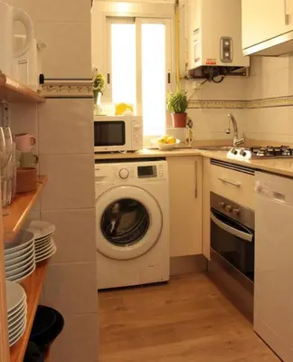 a kitchen with a washing machine and a microwave at Comfortable apartment. Very central and quiet. in Barcelona