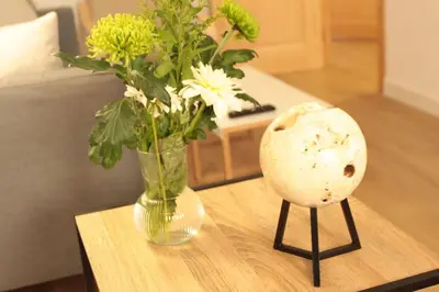 a vase of flowers sitting on a table with a vase at Comfortable apartment. Very central and quiet. in Barcelona
