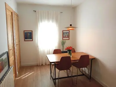 a dining room with a table and chairs and a window at Comfortable apartment. Very central and quiet. in Barcelona