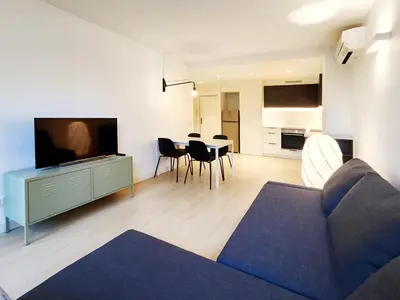 a living room with a couch and a tv and a table at Moderno Apartamento en Terrassa Centro in Terrassa