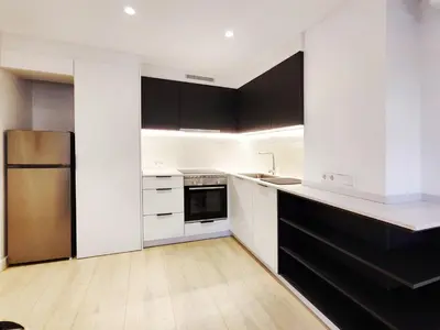 a kitchen with white cabinets and black appliances at Moderno Apartamento en Terrassa Centro in Terrassa