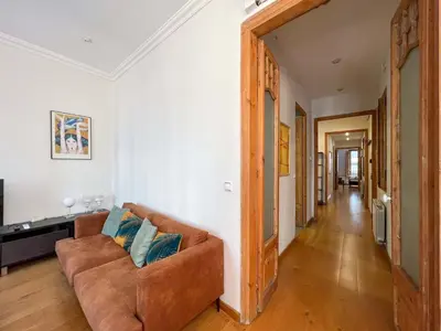 a living room with a brown couch and a hallway at Stay U-nique Apartments Mistral II in Barcelona