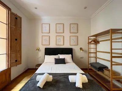 a bedroom with a bed with white sheets and a ladder at Stay U-nique Apartments Mistral II in Barcelona