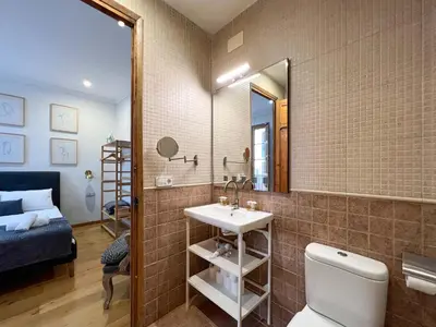 a bathroom with a sink and a toilet and a mirror at Stay U-nique Apartments Mistral II in Barcelona