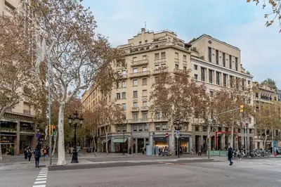 a large building on a city street with people walking at Canela Homes BARCELONA EIXAMPLE in Barcelona