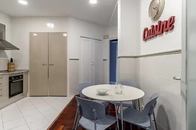 a kitchen with a white table and blue chairs at Canela Homes BARCELONA EIXAMPLE in Barcelona