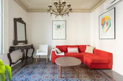 a living room with a red couch and a table at Canela Homes BARCELONA RAMBLA CAT in Barcelona