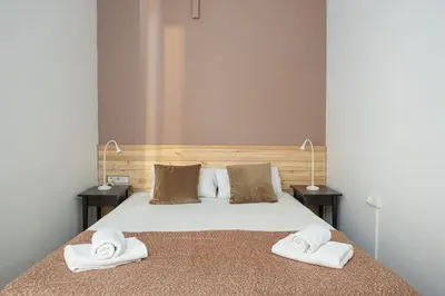 a bedroom with a bed with two towels on it at Canela Homes BARCELONA RAMBLA CAT in Barcelona