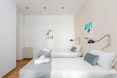 two beds in a room with white walls at Canela Homes BARCELONA CONSELL in Barcelona