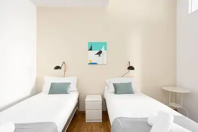 two beds in a room with white walls at Canela Homes BARCELONA CONSELL in Barcelona