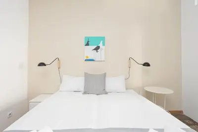 a bedroom with a white bed with two lamps at Canela Homes BARCELONA CONSELL in Barcelona