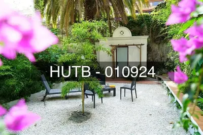 a table and chairs in a garden with flowers at Canela Homes BARCELONA CONSELL in Barcelona