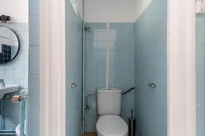 a bathroom with a toilet and a shower with blue tiles at Canela Homes BARCELONA RAMCAT37 in Barcelona