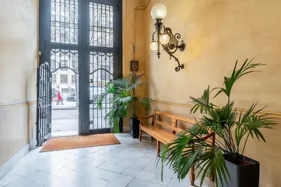a hallway with a bench and plants and a chandelier at Canela Homes BARCELONA RAMCAT37 in Barcelona