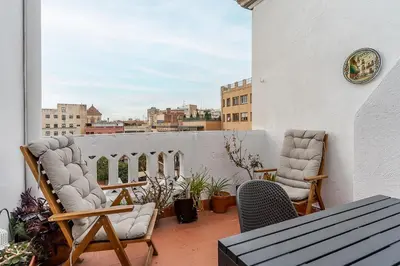 a balcony with chairs and a table on a roof at Canela Homes BARCELONA RAMCAT37 in Barcelona