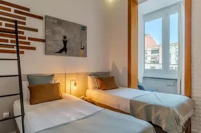 two beds in a room with a window at Canela Homes BARCELONA ART in Barcelona